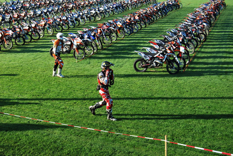 Massenstart einer Enduro-Veranstaltung: Fahrer laufen zu den in Reihen abgestellten Motorrädern