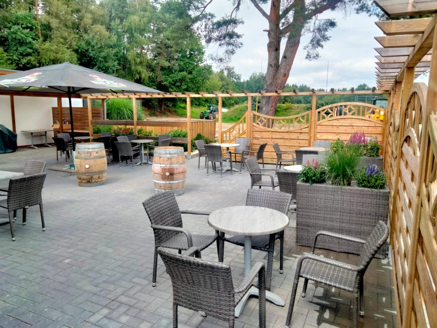 Außenbereich der Gastronomie im Hoope Park Wulsbüttel Außenbereich der Gastronomie im Hoope Park Wulsbüttel: Tische unter der Pergola mit Blick auf das Gelände